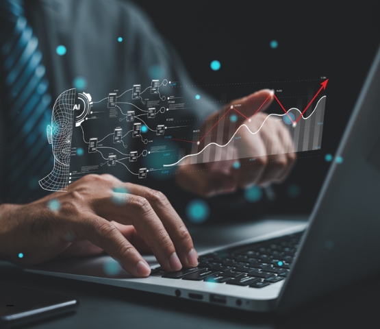 Personne utilisant un ordinateur portable avec une interface numérique illustrant des données, de l’intelligence artificielle et des graphiques d’analyse en surimpression