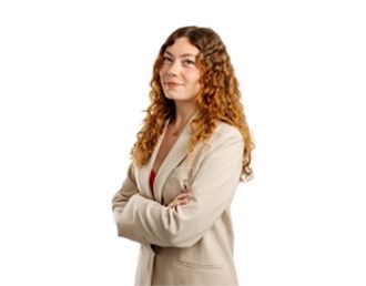 Portrait professionnel d’Arielle Chesnel, femme aux cheveux bouclés portant une veste beige, posant les bras croisés sur fond neutre.