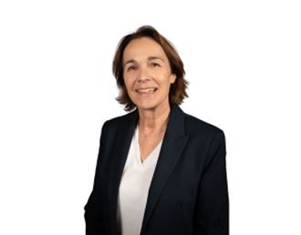Portrait professionnel de Virginie Puyguiraud, femme souriante aux cheveux courts, portant une veste sombre et un chemisier clair sur fond neutre.
