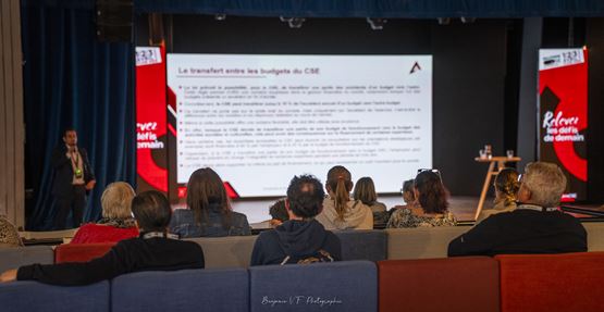 Participants assis face à une scène lors d’une conférence SolutionsCSE Les Rendez-Vous, avec intervenant et présentation projetée à l’écran